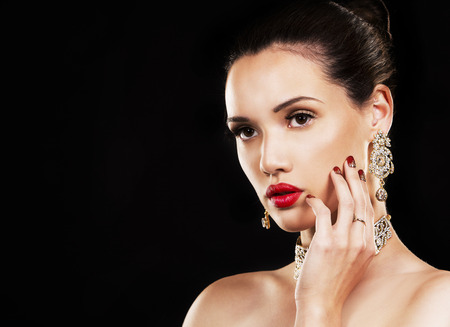 beautiful woman with dark makeup and red lipstick posing on black backgroundの写真素材