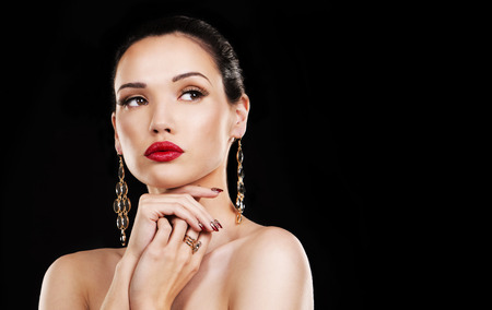 beautiful woman with dark makeup and red lipstick posing on black backgroundの写真素材