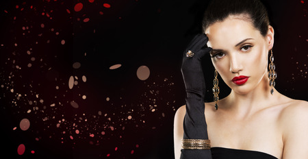 beautiful woman with dark makeup and red lipstick posing on black backgroundの写真素材