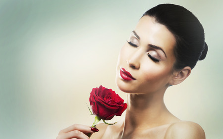 beautiful woman with dramatic makeup and red lips. Red flower rose.の写真素材