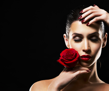 beautiful woman with dramatic makeup and red lips. Red flower rose.の写真素材