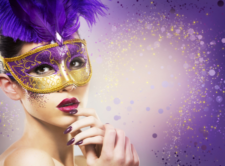 beautiful woman with dramatic mekaup and pruple lipstick wearing puprle mask. Light background. Golden.の写真素材
