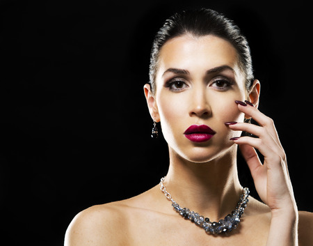 romantic woman with dramatic makeup and nailpolish. Big blue silver fashion necklace. Black background.の写真素材