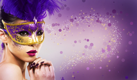 beautiful woman with dramatic mekaup and pruple lipstick wearing puprle mask. Light background. Golden.の写真素材