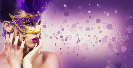 beautiful woman with dramatic mekaup and pruple lipstick wearing puprle mask. Light background. Golden.の写真素材