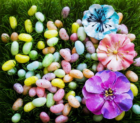 arrangement of colorful easter jelly bean eggs laid on grassの写真素材