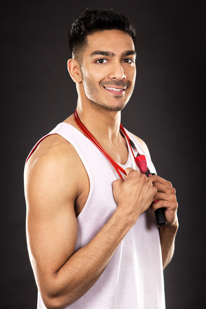 young fit indian man wearing workout outfit on dark backgroundの写真素材