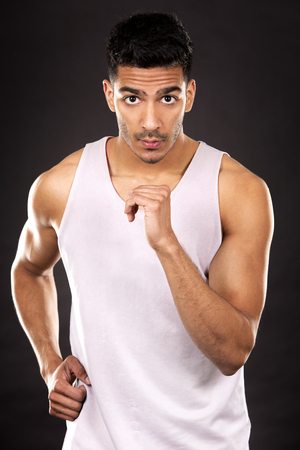 young fit indian man wearing workout outfit on dark backgroundの写真素材
