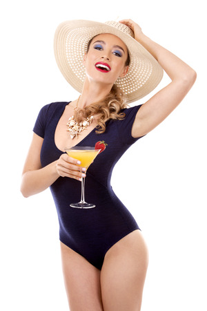 beautiful woman with dark makeup and red lipstick posing on white background wearing bright blue swimsuit and hatの写真素材