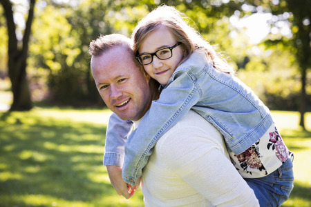 young family, father and daughter wearing casual outfits, outdoors in the parkの写真素材