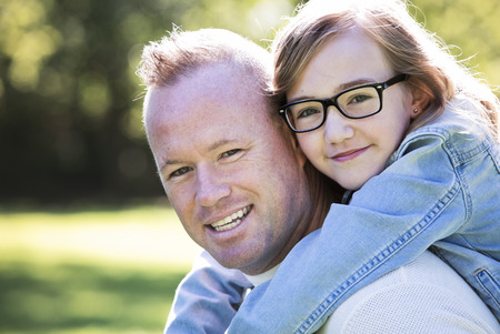 young family, father and daughter wearing casual outfits, outdoors in the parkの写真素材
