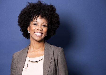 beautiful casual black woman wearing jacket and jeans on dark blue backgroundの写真素材