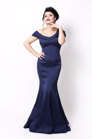 elegant woman wearing evening gown in dark blue or navy color on white backgroundの写真素材