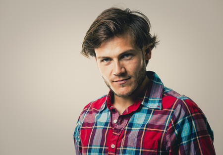 Fashion portrait of a handsome man with trendy hairstyle in a stylish shirt on light green backgroundの写真素材
