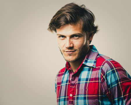 Fashion portrait of a handsome man with trendy hairstyle in a stylish shirt on light green backgroundの写真素材