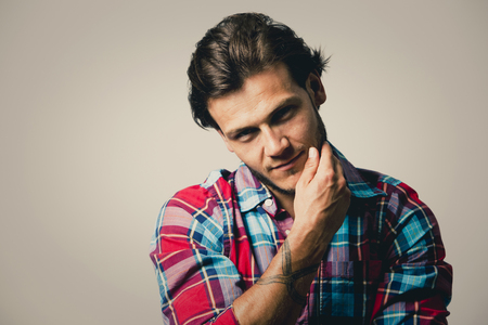 Fashion portrait of a handsome man with trendy hairstyle in a stylish shirt on light green backgroundの写真素材