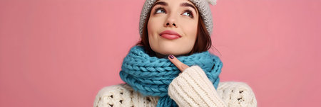 panoramic shot of young woman in winter hat and scarf isolated on pinkの素材