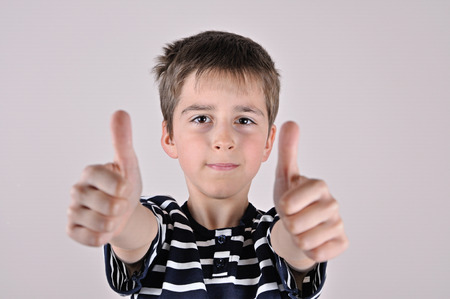Young boy wearing T-shirt with thumbs upの写真素材