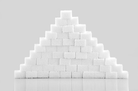 Pile of sugar cubes isolated on gray backgroundの写真素材