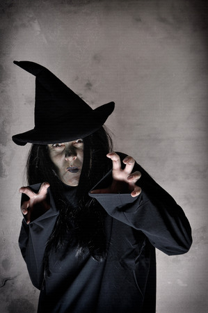 Spooky halloween witch with green face casting spellsの写真素材
