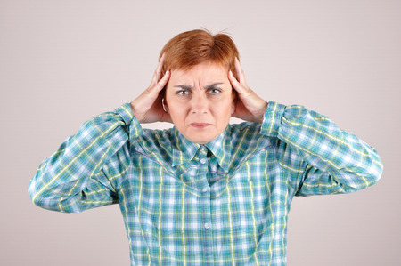 Angry and nervous woman with hands on the headの写真素材