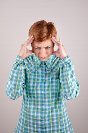 Desperate and depressed woman holding her headの写真素材
