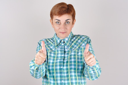 Happy and satisfied woman with thumbs upの写真素材