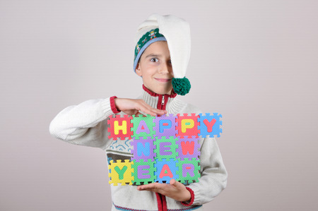 Cute young boy holding a Happy New Year sign made of alphabet puzzle piecesの写真素材