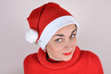 Portrait of a woman with Santa hat and a red turtleneck sweaterの写真素材