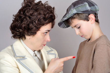 Woman scolding and pointing her index finger at the young boy. Vintage style photoの写真素材