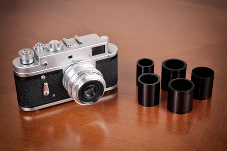 Retro camera and films on the brown table. Vintage style photo