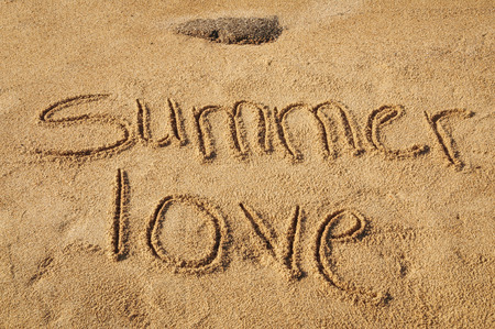 The words Summer Love written in the sand on the beachの写真素材