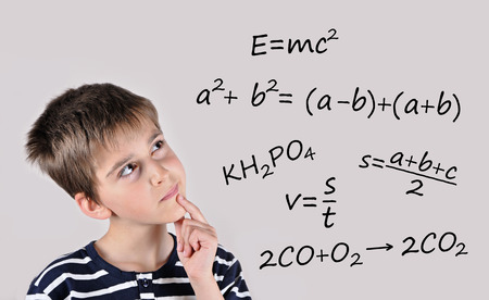 Thoughtful cute schoolboy thinking about school subjectsの写真素材