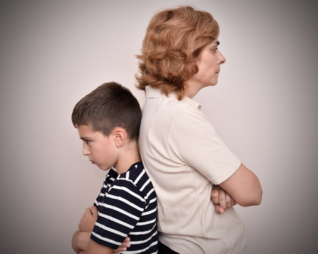 Angry mother and son turning their backs to each otherの写真素材