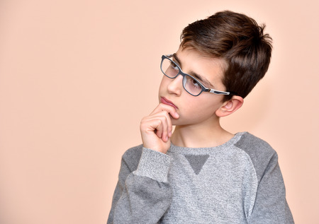 Thoughtful cute young boy with glassesの写真素材