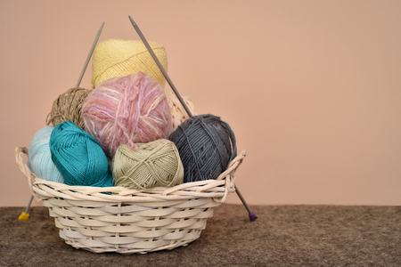 Knitting accessories in the basket on the woolen backgroundの写真素材