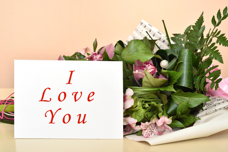 Bouquet of flowers and greeting card with I Love You message. Selective focus.の写真素材
