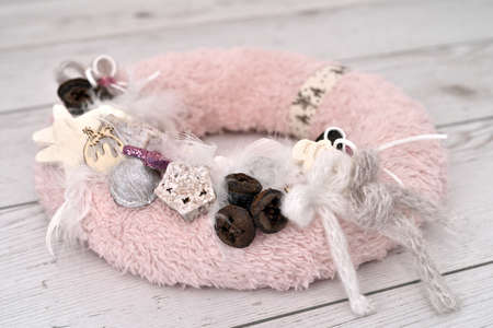 Decorated handmade Christmas wreath on the rustic wooden table. Close-up. Selective focus.の写真素材