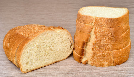 Stack of sliced fresh homemade white bread on the rustic wooden tableの写真素材