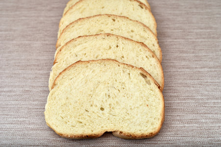 Stack of sliced fresh homemade white bread on the rustic wooden tableの写真素材