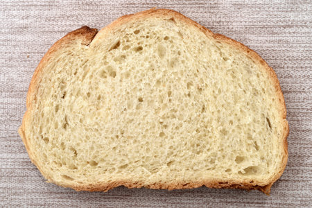 Slice of fresh homemade white bread on the rustic wooden table. Close-up. Top view.の写真素材