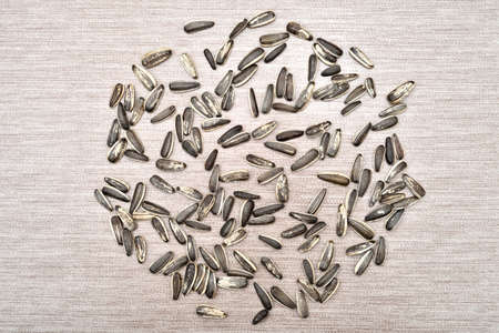 Heap of striped black and white sunflower seeds on the rustic wooden table. Top view.の写真素材