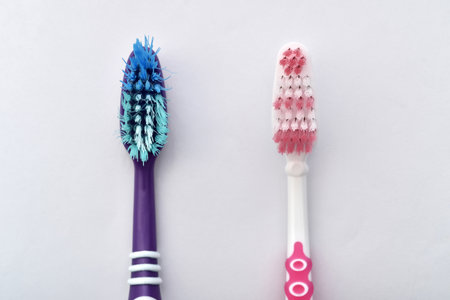 Old and new toothbrush isolated on the pale blue background. Compared before and after using. Dental concept. Close-up.の写真素材