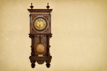 Old clock hanging on the grunge texture wall. Copy space on the right side. Retro style photo filter applied.の写真素材