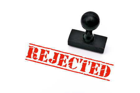 Wooden rubber stamp with the word rejected on the white paperの写真素材