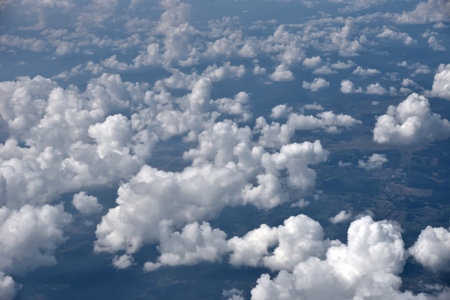 Aerial view of the thick and dramatic clouds from the airplane window. Airplane above clouds. Creative background for design. Flying, traveling and holidays concept.の写真素材