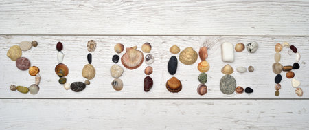 Word summer made of sea shells, snails and pebbles on the vintage white scratched wooden texture. Top view. Close-up. Copy space.の写真素材
