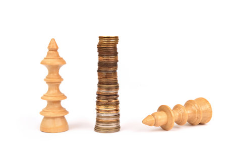 Stack of coins between the white wooden king and queen chess pieces lying down on the white background. Copy space. Battle for money concept.の写真素材