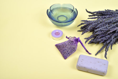 Bouquet of lavender flowers and lavender products on the yellow background. Copy space on the left side. Selective focus.の写真素材