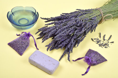 Bouquet of lavender flowers and lavender products on the yellow background. Selective focus.の写真素材